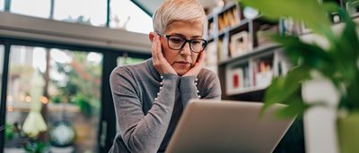 Gestresste Frau sitzt vor Laptop