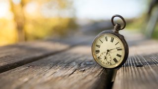 Taschenuhr auf Holztisch wartet auf Zeitumstellung.