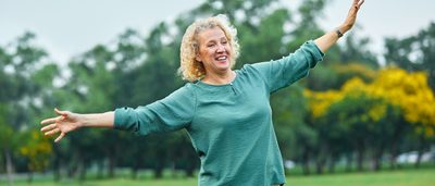 Ältere Frau balanciert im Freien.