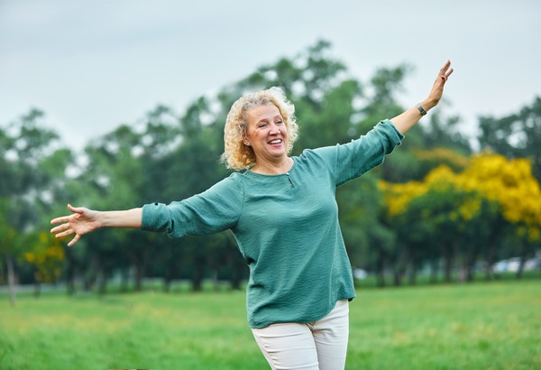 Ältere Frau balanciert im Freien