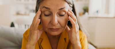 Frau mit gutartigem Lagerungsschwindel hält sich Hände an die Schläfen.