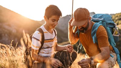 Mittelalter Mann und Junge sitzen in der Hocke auf einem Feld in der Natur