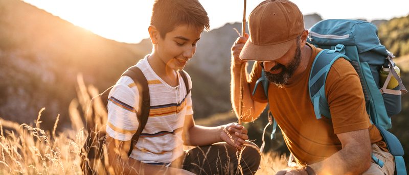 Mittelalter Mann und Junge sitzen in der Hocke auf einem Feld in der Natur