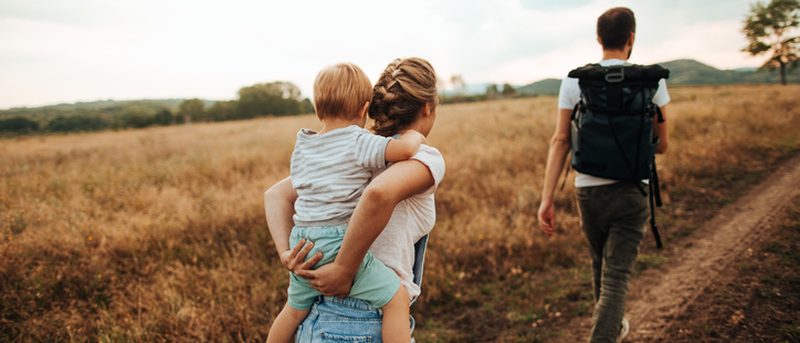 Eltern tragen Sohn auf dem Rücken