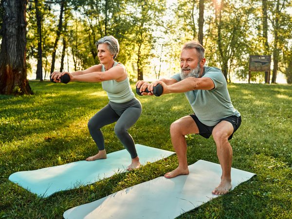 Älteres Paar macht Fitnessübungen im Park – Bewegung bei Gelenkschmerzen