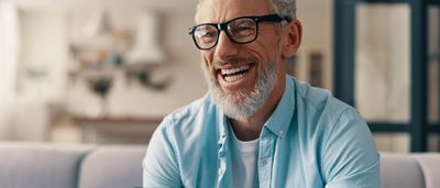 Mann mit Brille lacht.