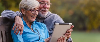 Mann und Frau lesen auf einem Tablet Tipps gegen Schwindel.