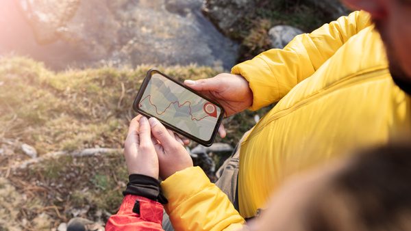 Zwei Personen gucken sich eine Wanderroute auf dem Smartphone an