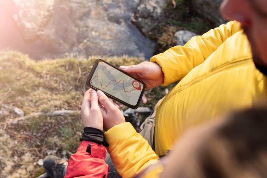 Zwei Personen gucken sich eine Wanderroute auf dem Smartphone an