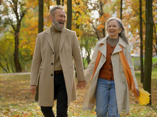 Ehepaar bei einem herbstlichen Spaziergang im Park – Ruhe und Entspannung als alltagsnahe Unterstützung für Herz und Kreislauf