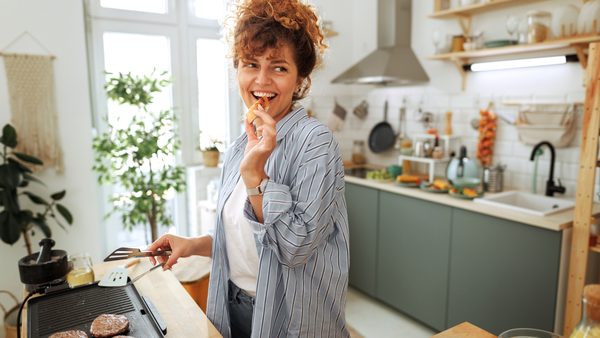 Frau steht in der Küche und kocht eine leichte Mahlzeit gegen Durchfall.