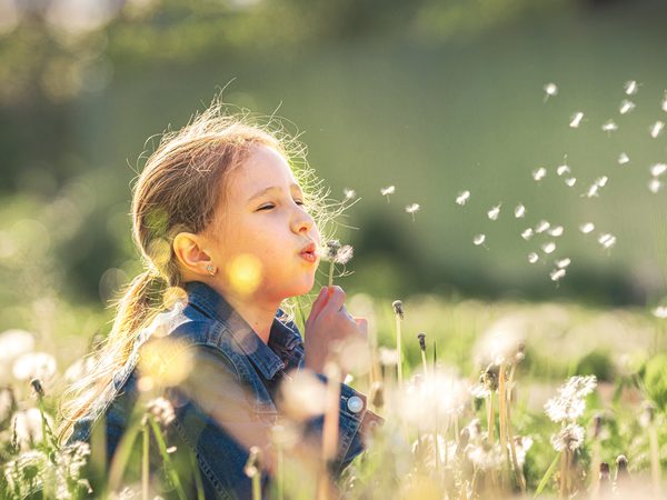 Ein fröhliches Kind genießt die Natur. Ausreichend Schlaf hilft, tagsüber energiegeladen und ausgeglichen zu sein.