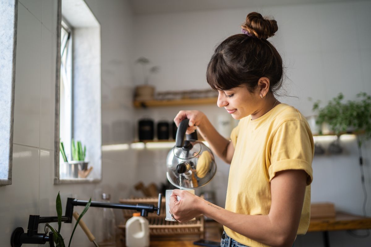 Freu gießt sich Tee in ihre Tasse