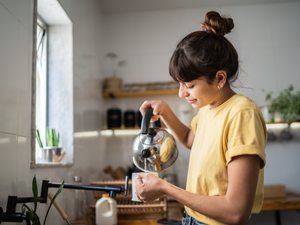 Freu gießt sich Tee in ihre Tasse