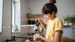 Freu gießt sich Tee in ihre Tasse