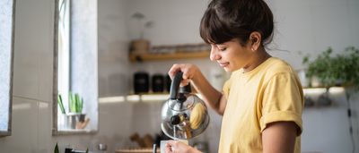 Freu gießt sich Tee in ihre Tasse