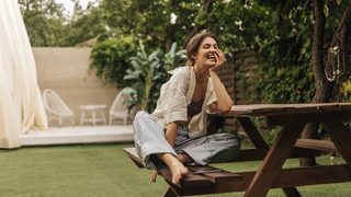 Junge Frau im Garten, Symbol für natürliche Linderung und Wohlbefinden bei PMS-Symptomen