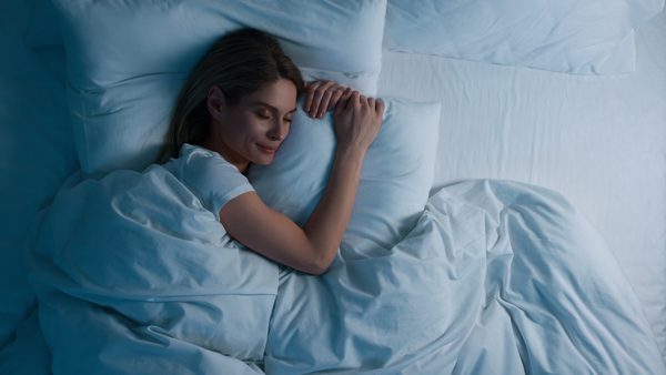 Frau schläft zufrieden in einem großen Bett