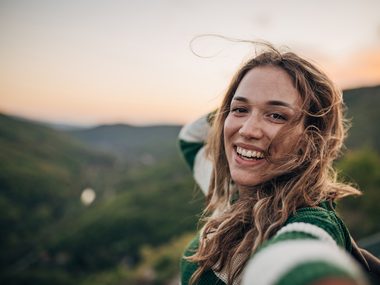 Fröhliche Frau mit langen Haaren in der Natur