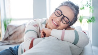 Frau liegt auf dem Sofa und ist dankbar