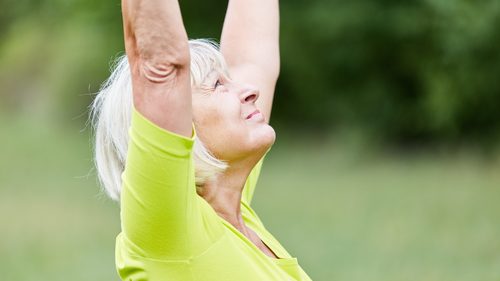Ältere Frau macht Gleichgewichtsübungen an der frischen Luft