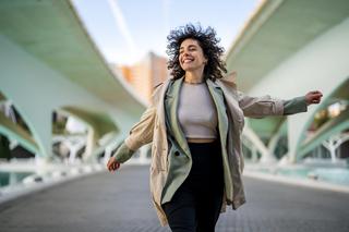 Frau auf einer Brücke, strahlend und frei – Hormone und ihr Einfluss auf den weiblichen Körper.