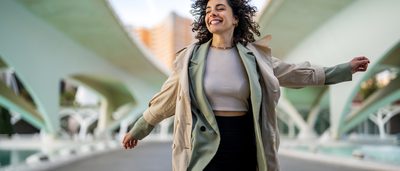 Frau auf einer Brücke, strahlend und frei – Hormone und ihr Einfluss auf den weiblichen Körper.