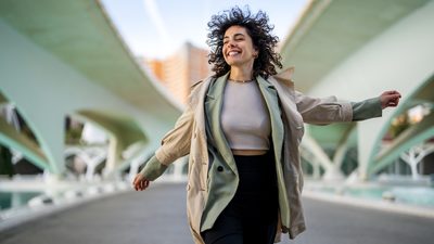 Frau auf einer Brücke, strahlend und frei – Hormone und ihr Einfluss auf den weiblichen Körper.