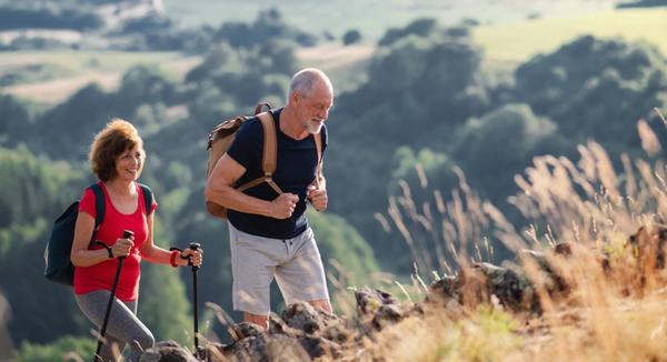 Älteres Paar geht in den Bergen Wandern - Entspannung durch Bewegung