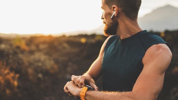 Mann mit Sportuhr schaut in die Ferne.