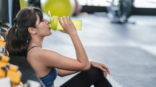Frau beim Sport trinkt einen Shake