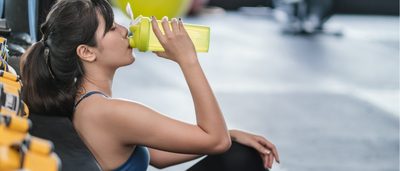 Frau beim Sport trinkt einen Shake