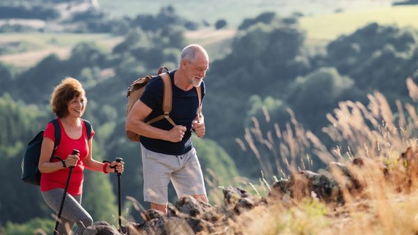Älteres Paar wandert mit Stöcken; Ratgeber zu Höhenmetern