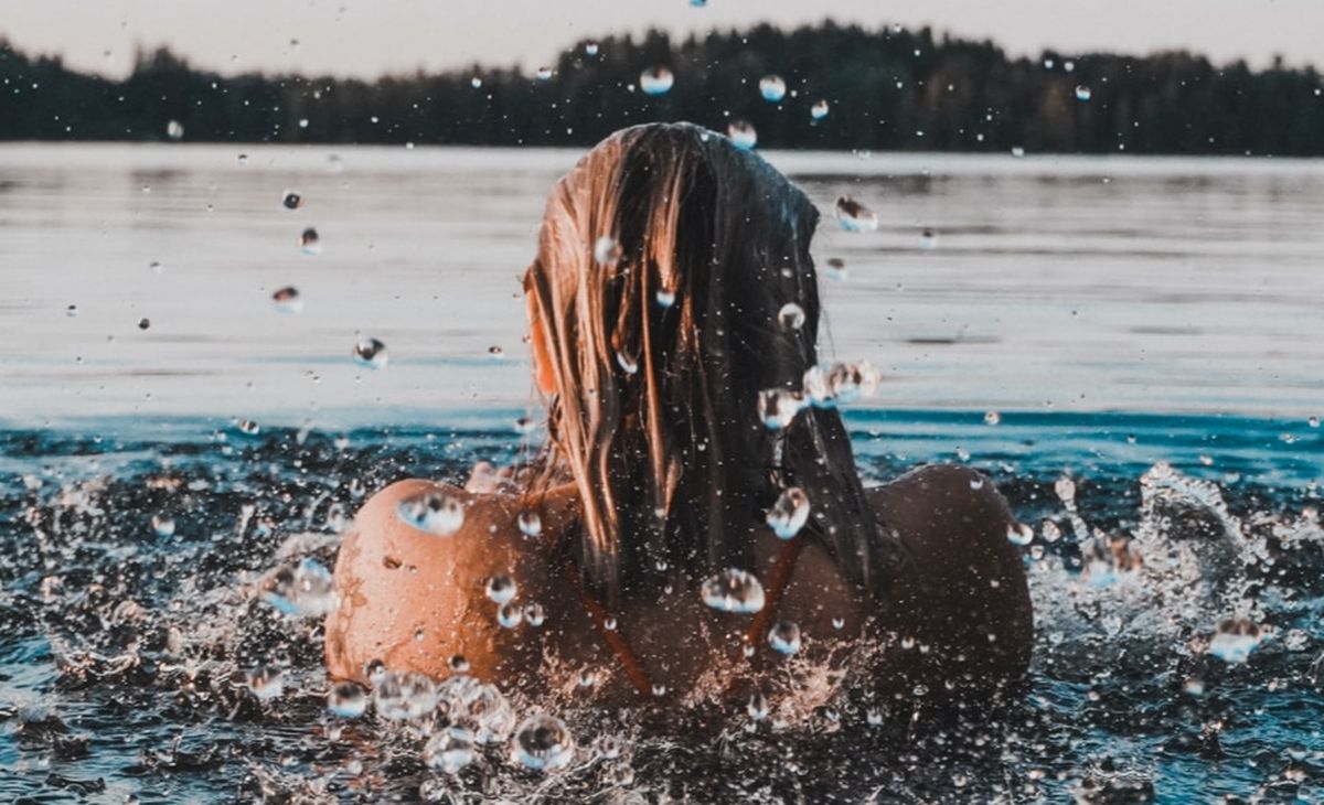 Frau schwimmt in einem See.