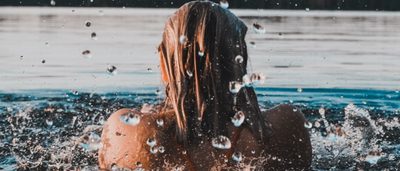 Frau schwimmt in einem See.