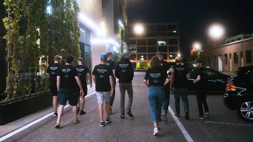 the hole team of dorfjungs walking on the streets in the night with the same shirt on