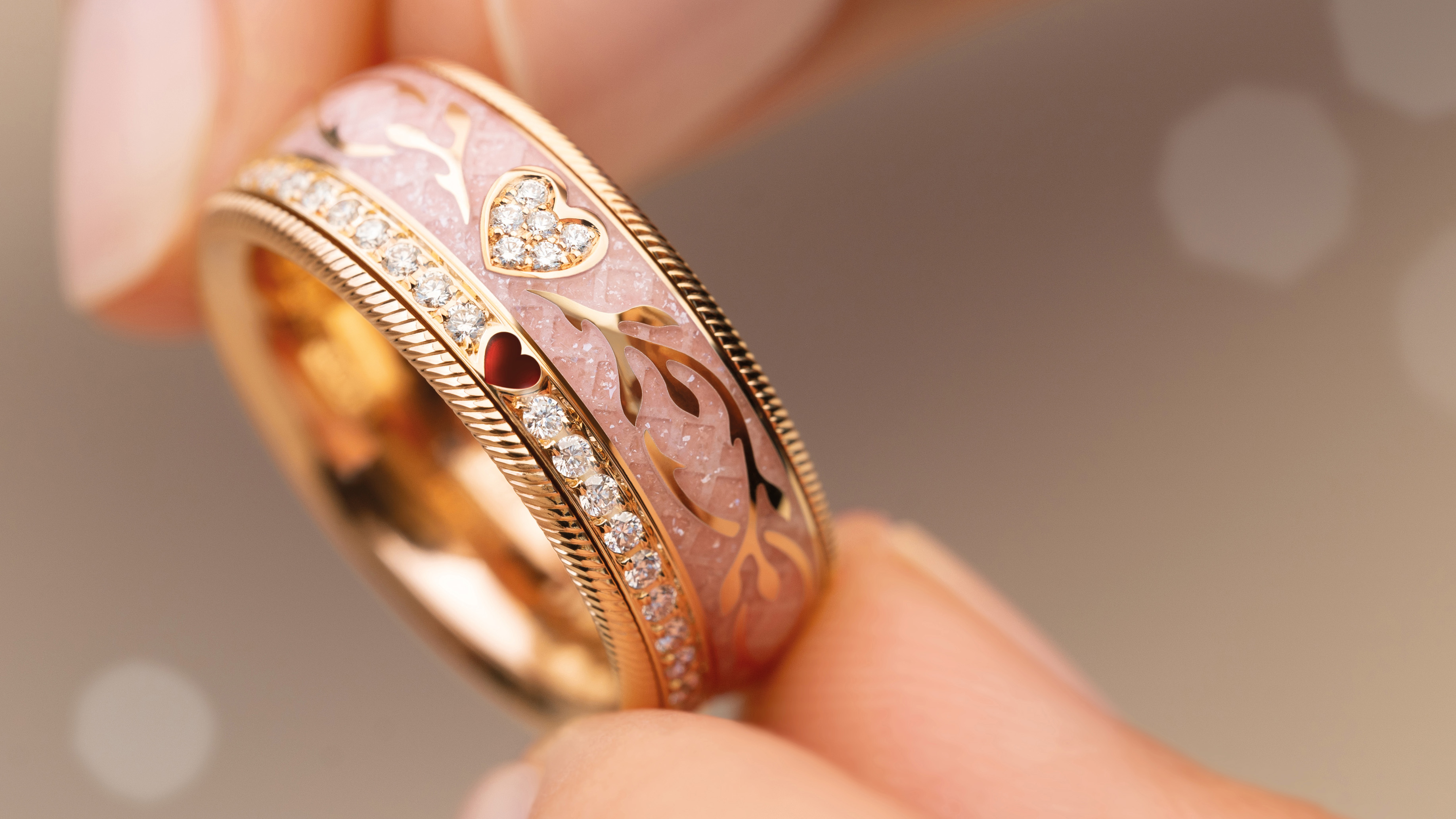 Der drehbare Ring EDEL VERGISSMEINNICHT. nude mit Herz aus 18-karätigem Gelbgold mit romantischen floralen Gravurelementen,funkelnden Brillanten und einem roten Herz.