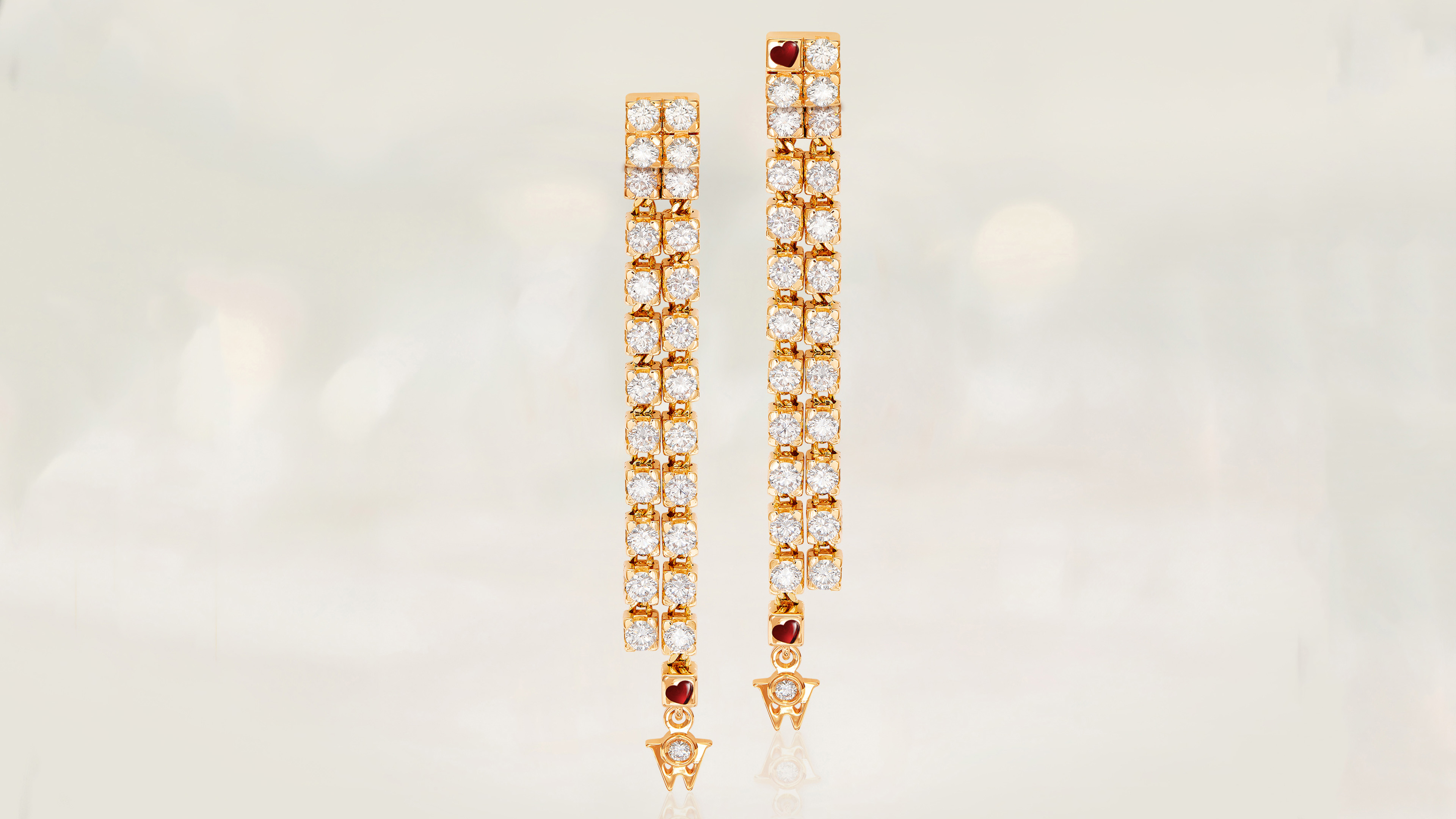 Die Ohrringe BRILLANTVERFÜHRUNG in 18-karätigem Gold gepaart mit funkelnden Brillanten. Auf grauem Mood Hintergrund.