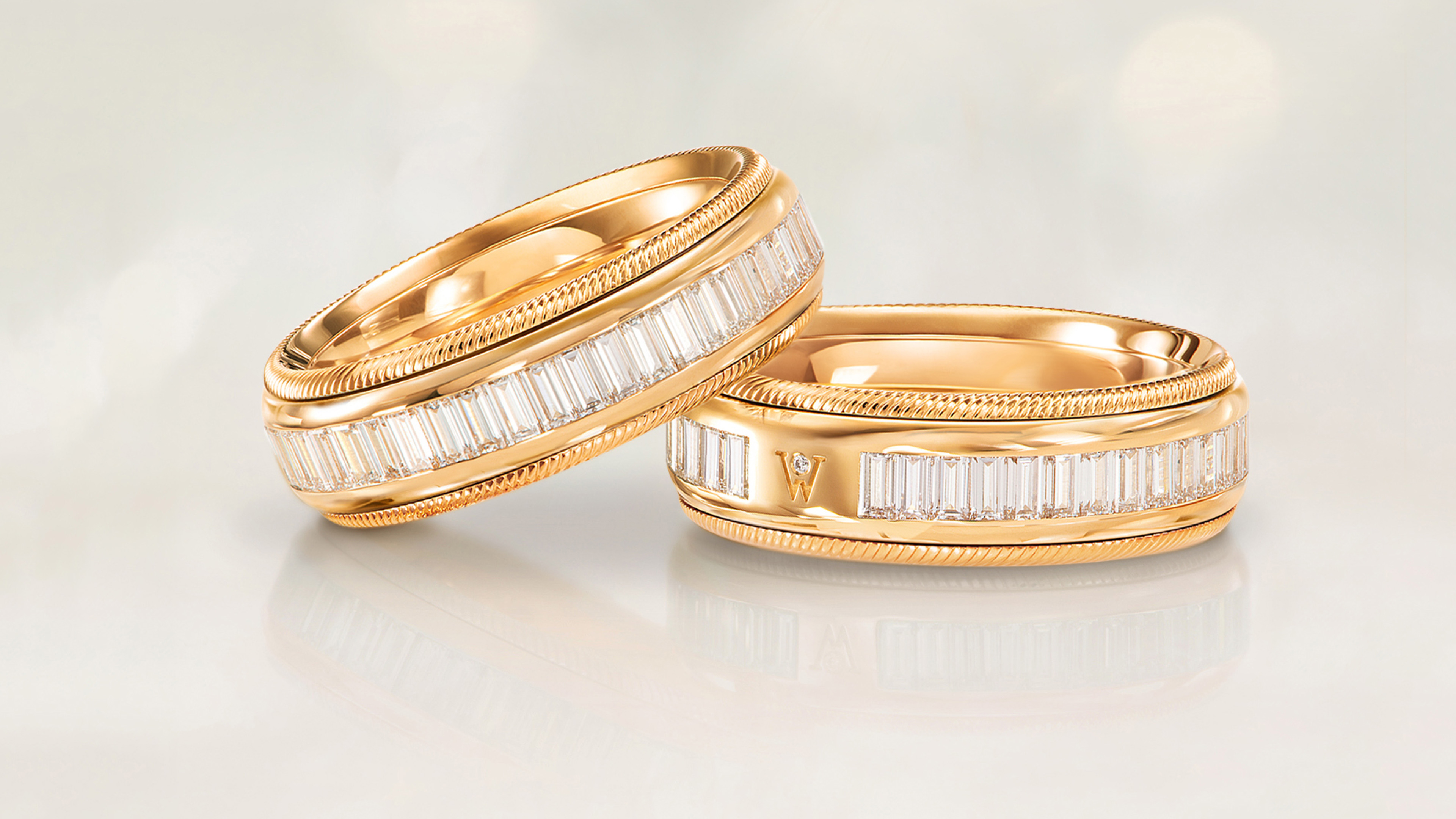 Der drehbare Ring BAGUETTE-ZAUBER aus 18 Karat Gold mit handgefassten lupenreinen Diamanten im Baguetteschliff von Wellendorff. Auf grauem Mood Hintergrund.