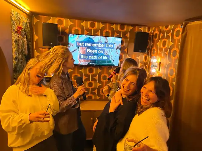 A group of people singing in the karaoke room in The Kenton Pub