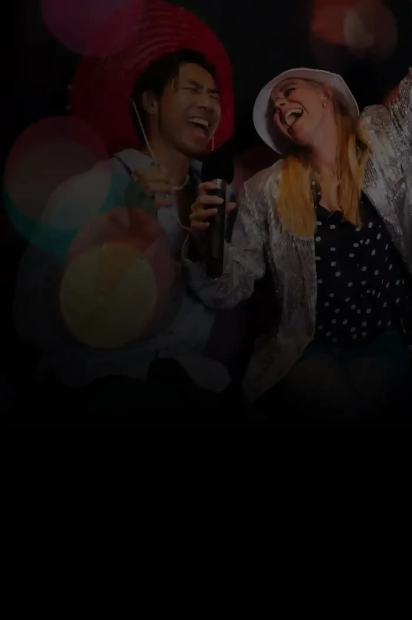 Two karaoke singers with bokeh effect.