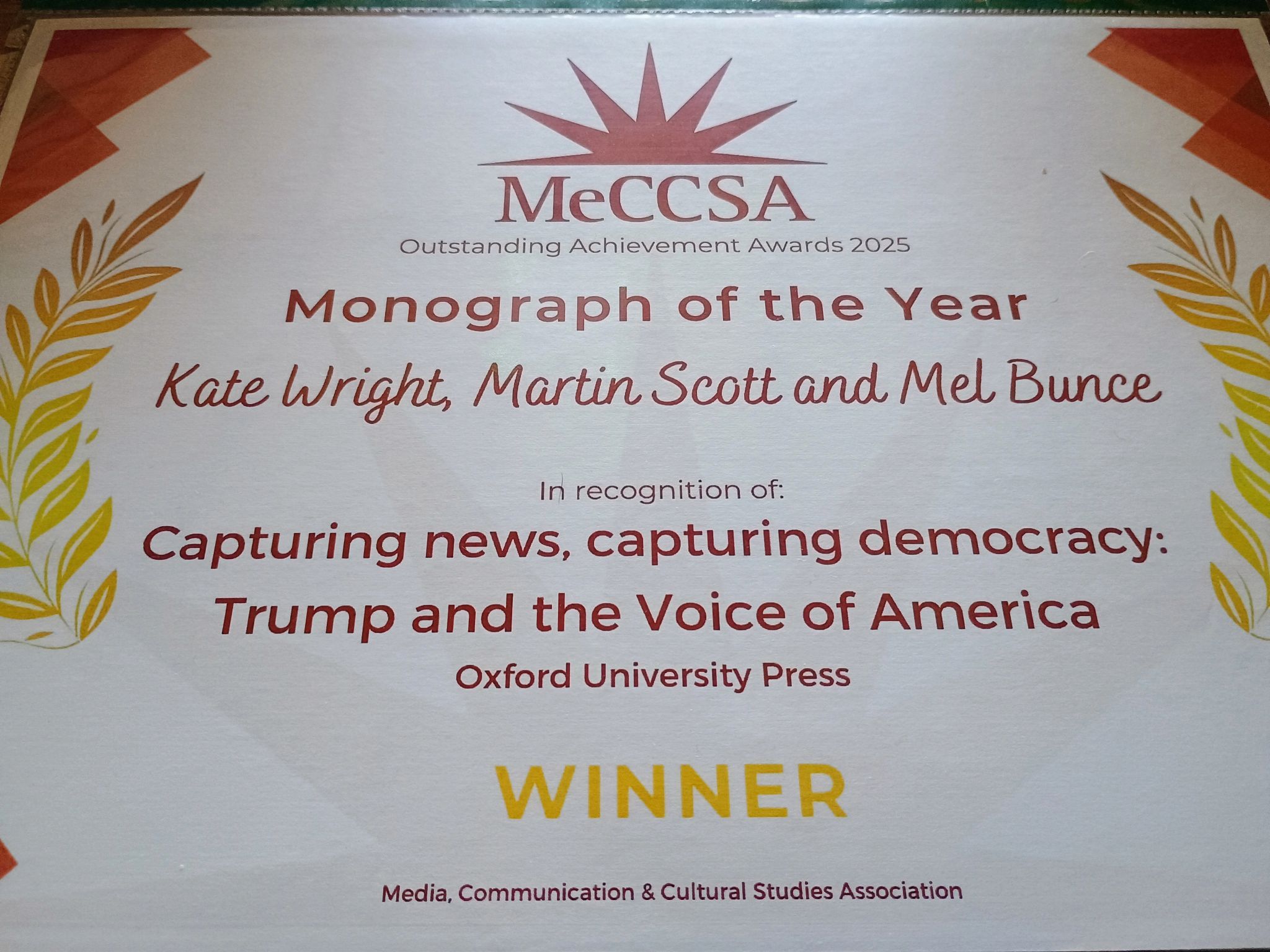 A certificate for Monograph of the Year in orange and yellow font