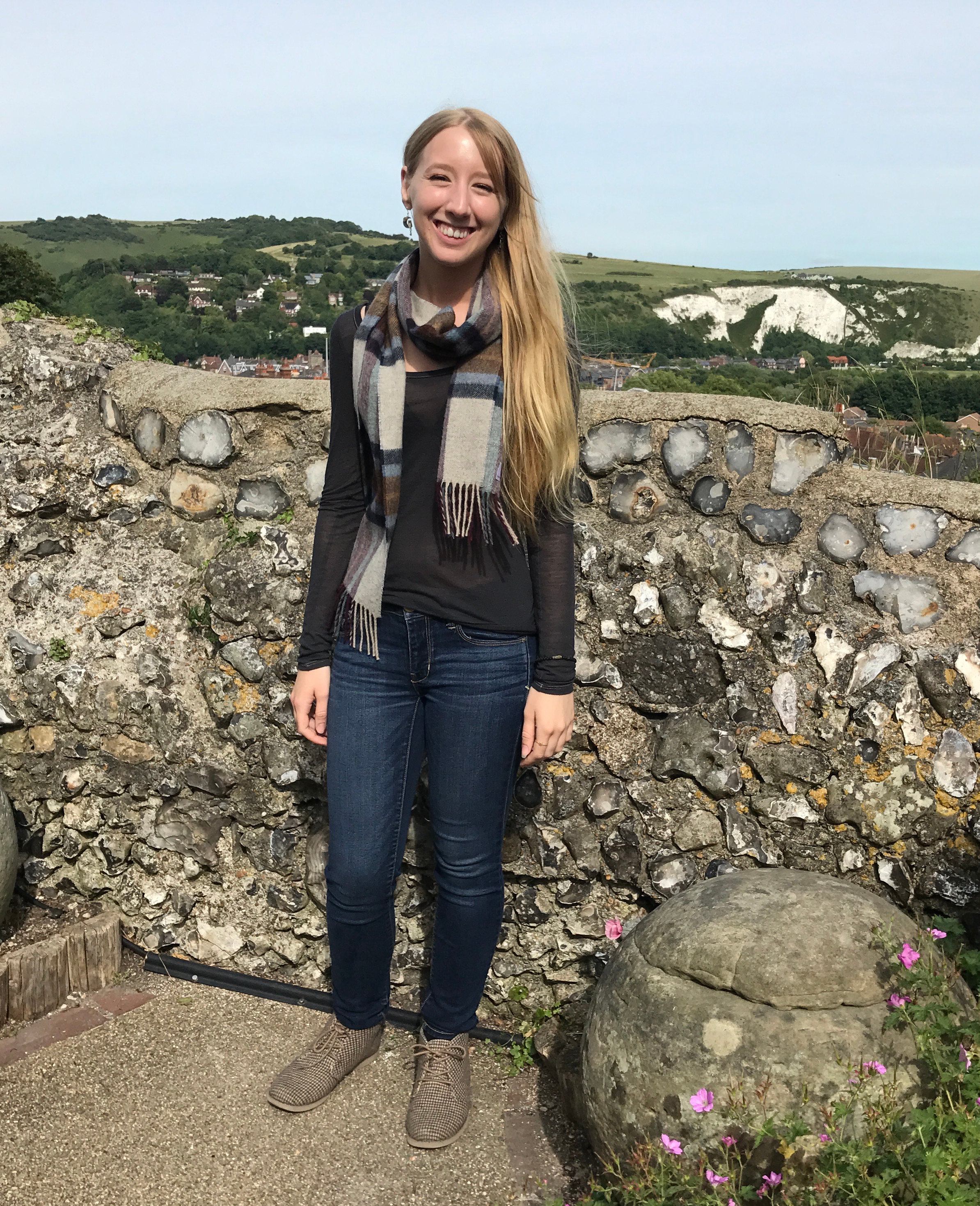 Picture of Amanda Hodes standing in front of brick wall in English countryside