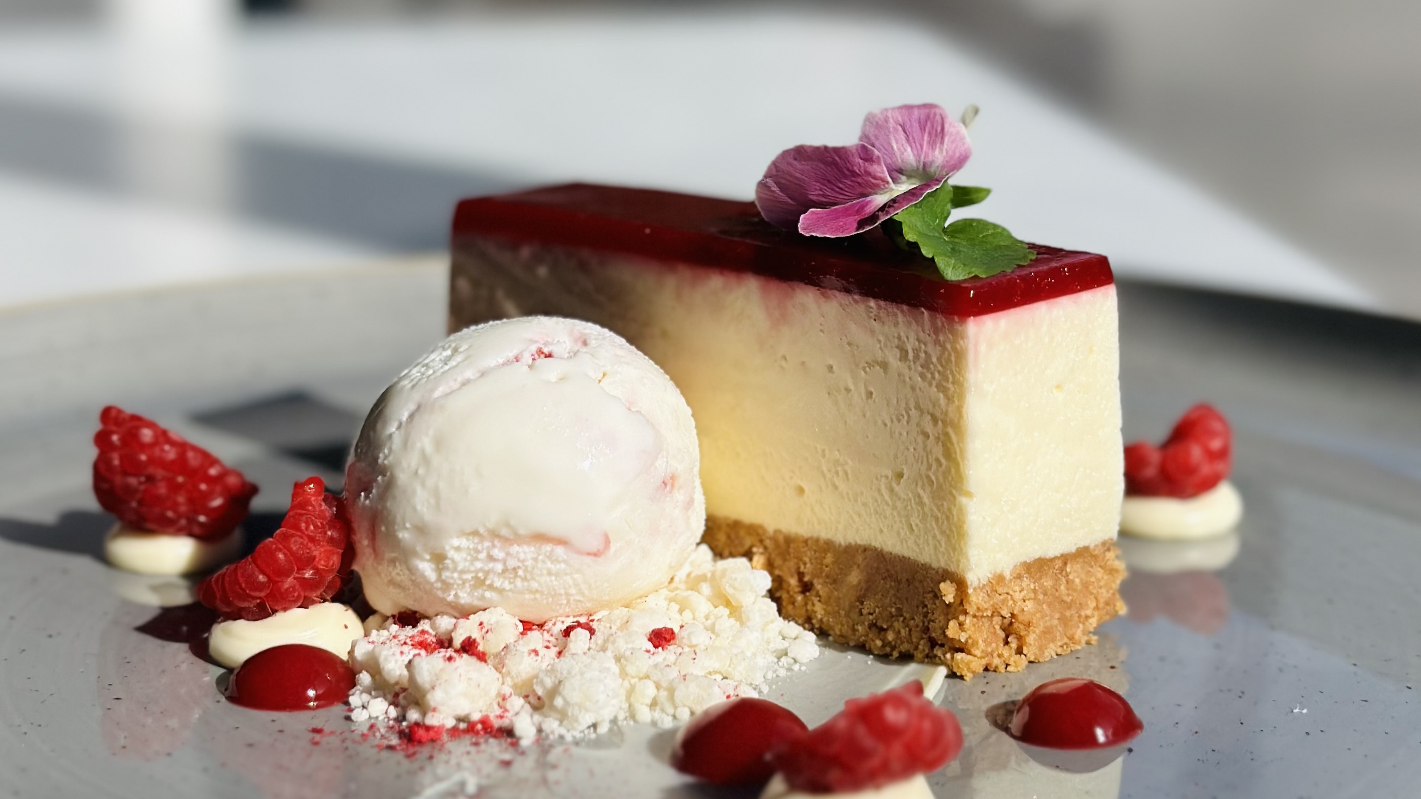 Cheesecake and ice cream on a plate.