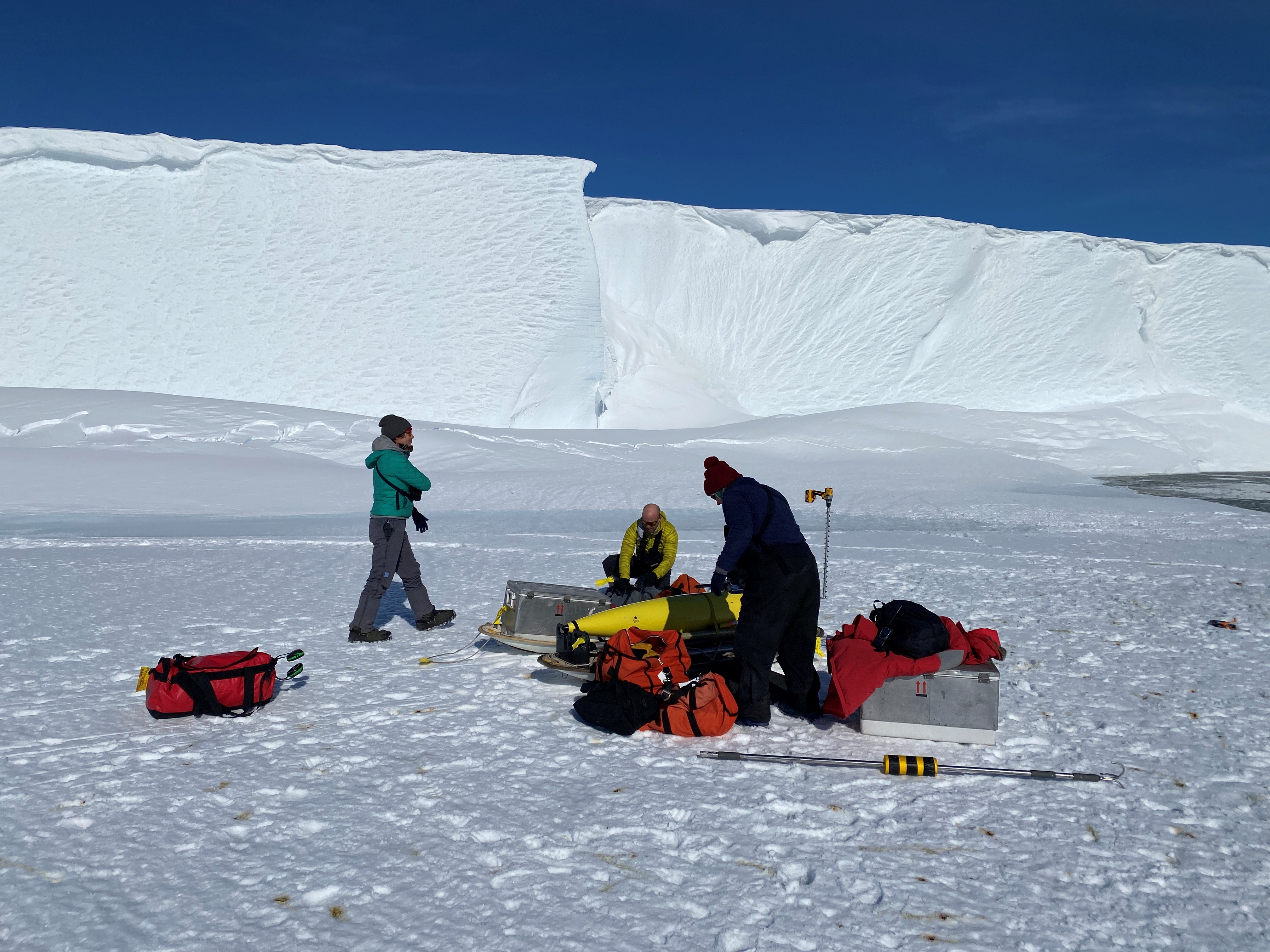 Deployment team preparing to launch the Seaglider Marlin into the Ross Sea, with the Ross Ice Shelf in the background