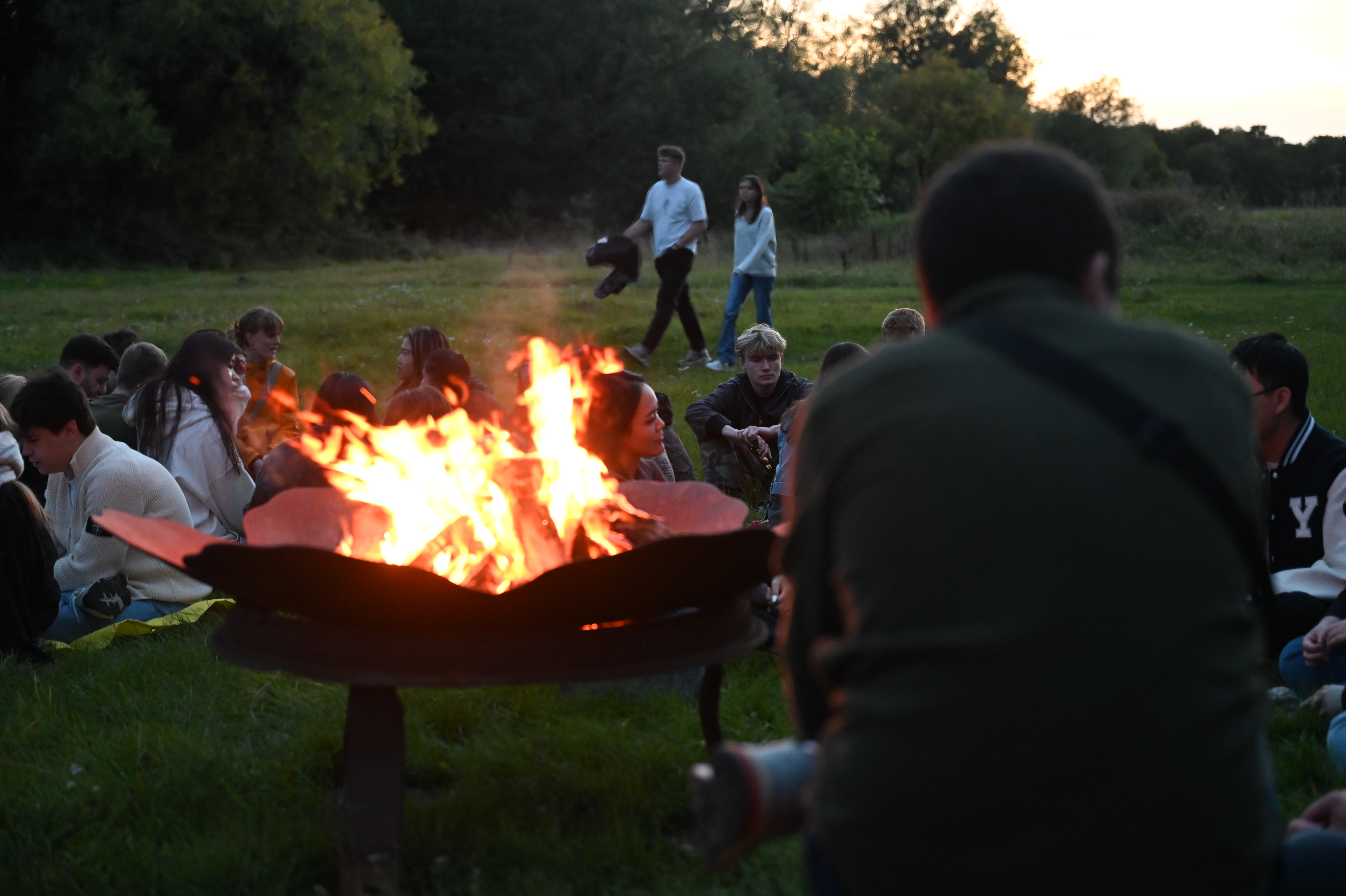 Students sitting around a firepit during Welcome Week