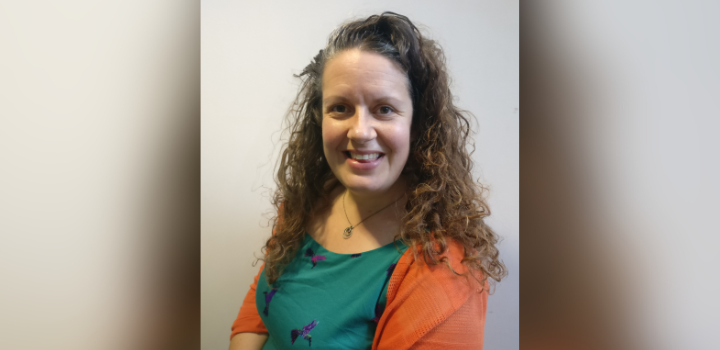 Prof Kelly Edmunds smiling, wearing a green top and orange cardigan