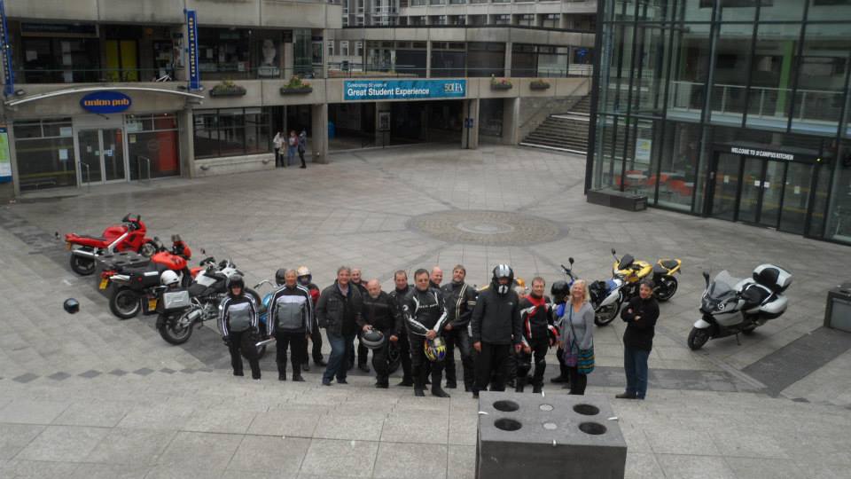 A group of UEA graduates on campus with motorcycles