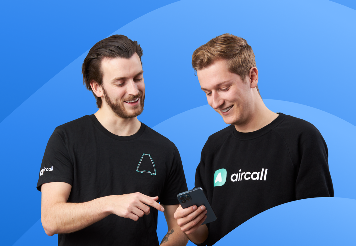 two people looking at a phone on a blue background