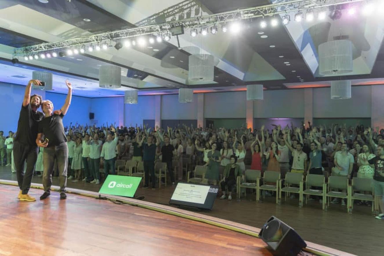 Group photo from Aircall's 2022 Company Offsite, featuring co-founder Olivier and Jonathan taking a selfie on stage